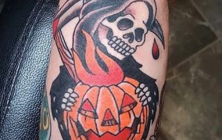 Tattoo of grim reaper with a pumpkin